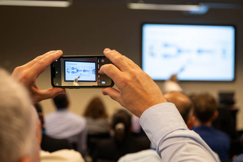 Deelnemer maakt foto van presentatie van parallelsessie ‘Is de functioneel beheerder in de toekomst een AI-systeem?